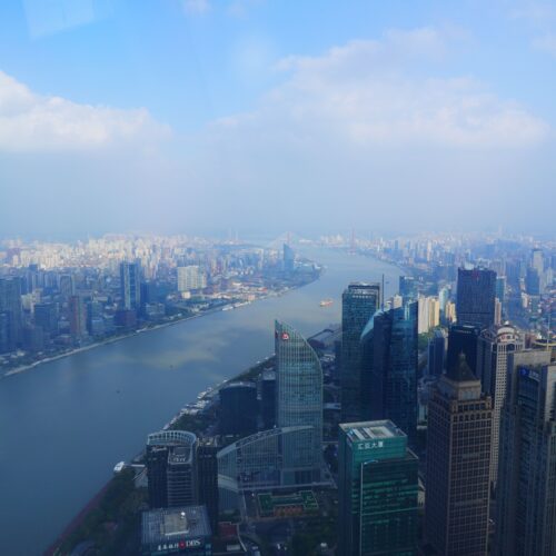 A breathtaking aerial cityscape of Shanghai, China, featuring skyscrapers along the Huangpu River.