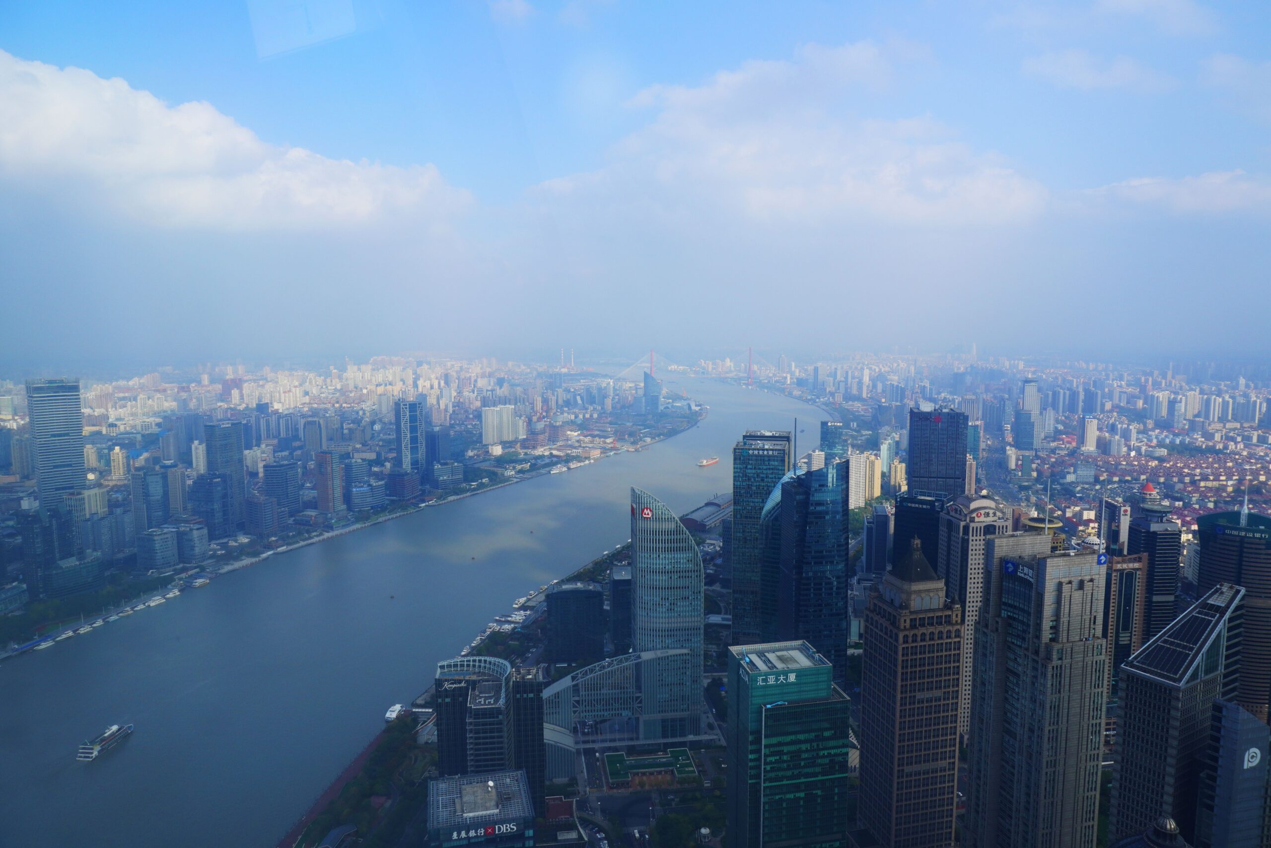 A breathtaking aerial cityscape of Shanghai, China, featuring skyscrapers along the Huangpu River.