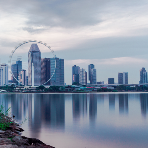 Captivating view of Singapore's skyline featuring the iconic Singapore Flyer reflecting over calm waters.
