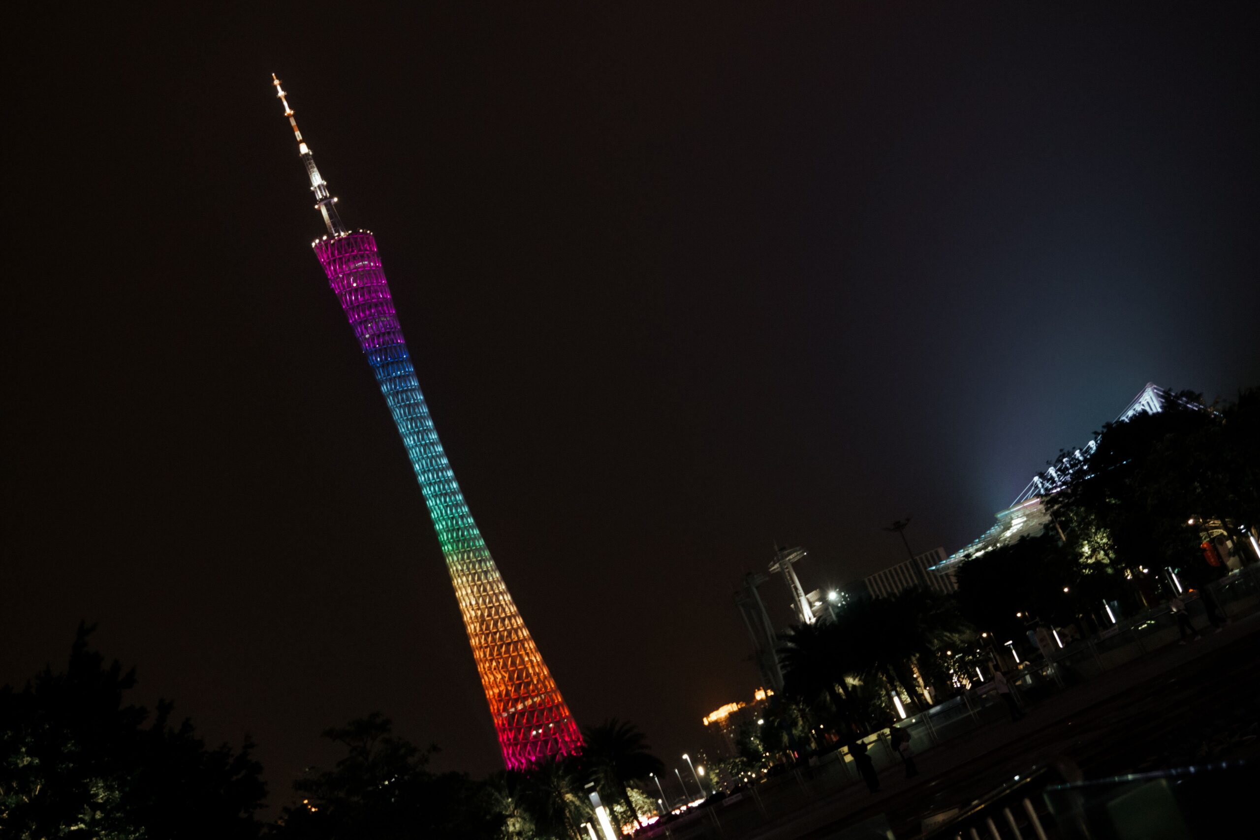 Vibrant night view of the illuminated Canton Tower in Guangzhou against a dark sky.
